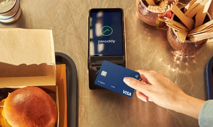 Waiter taking table payment using TapaPay handheld terminal